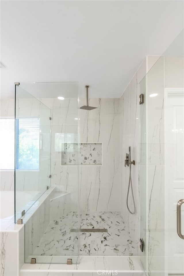 bathroom featuring a shower with shower door