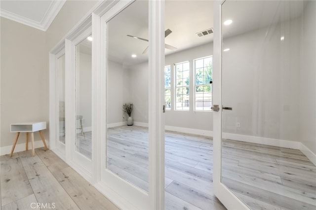 entryway featuring french doors, crown molding, and light hardwood / wood-style flooring