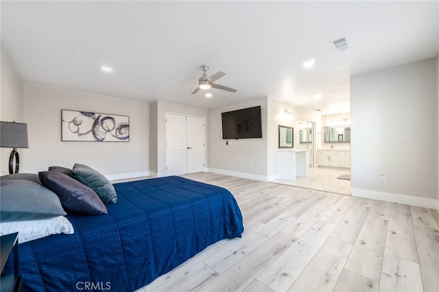 bedroom with light hardwood / wood-style floors, a closet, ensuite bathroom, and ceiling fan