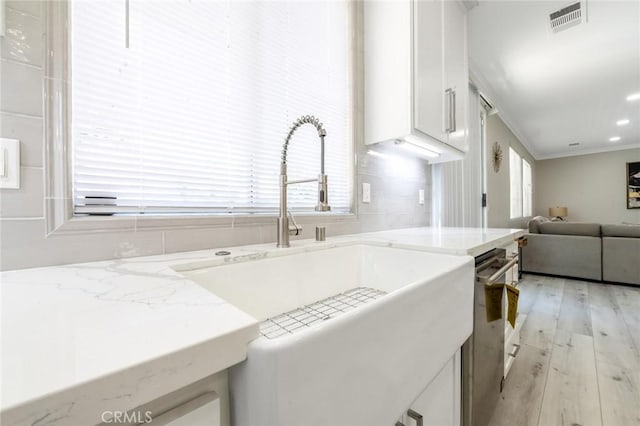 4806 W Concord Ave, Visalia, CA 93277 - kitchen featuring a sink, white cabinetry, ornamental molding, light wood-style flooring, and stainless steel dishwasher