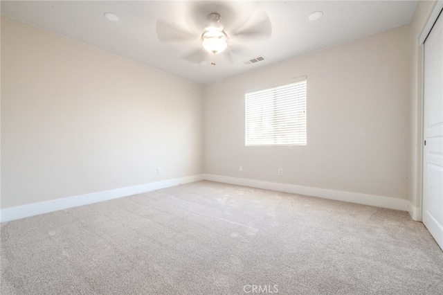 carpeted spare room with ceiling fan