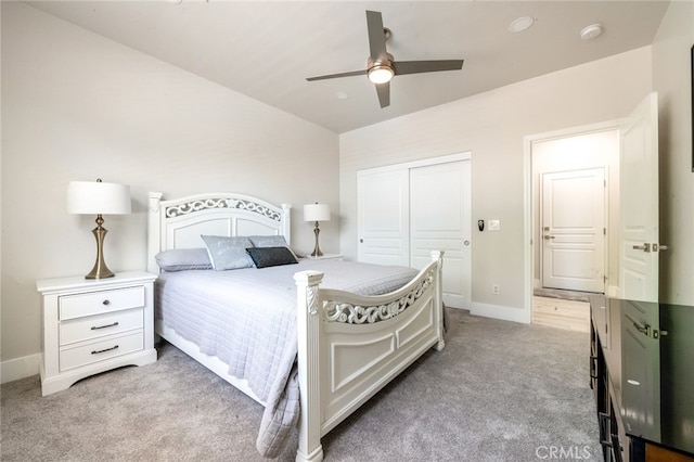 bedroom featuring a closet, light colored carpet, and ceiling fan