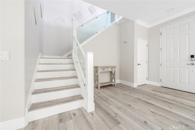 staircase featuring crown molding and wood-type flooring