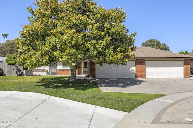 view of property hidden behind natural elements featuring a garage and a front yard