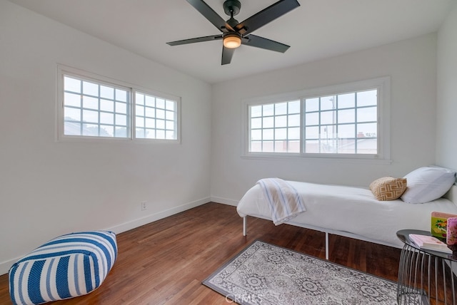 bedroom with hardwood / wood-style floors, multiple windows, and ceiling fan