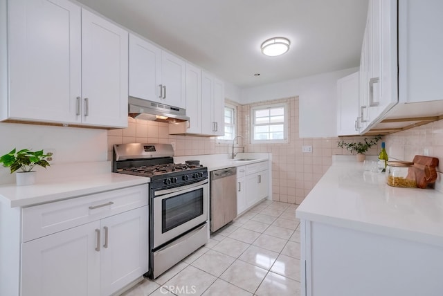 kitchen with sink, white cabinets, stainless steel appliances, and light tile patterned floors