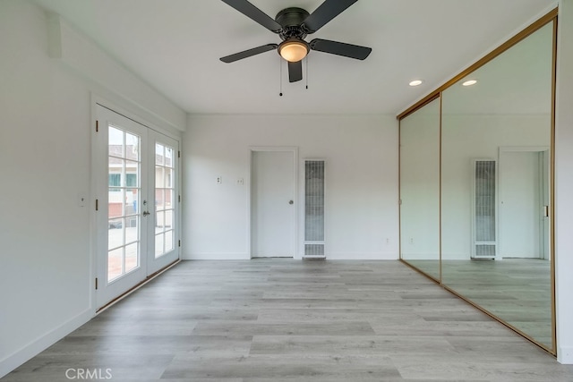 spare room featuring ceiling fan, light wood-type flooring, and french doors