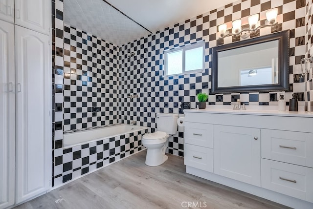 full bathroom featuring hardwood / wood-style floors, toilet, tile walls, and a wealth of natural light