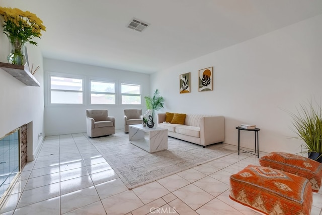 living room with light tile patterned floors and a fireplace