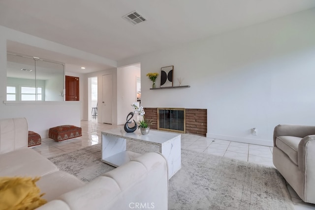 tiled living room featuring a brick fireplace