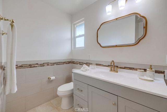 bathroom featuring tile patterned floors, vanity, tile walls, and toilet