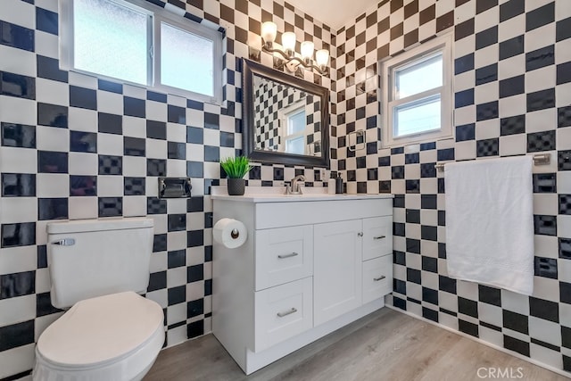 bathroom featuring hardwood / wood-style flooring, toilet, and tile walls