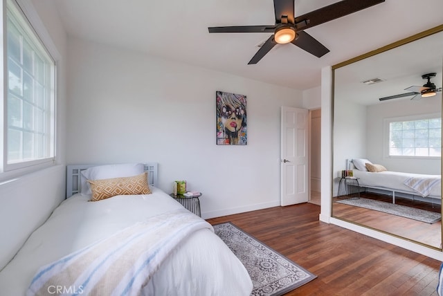 bedroom with dark hardwood / wood-style flooring and ceiling fan