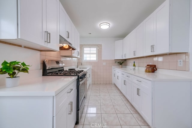 kitchen featuring sink, white cabinets, light tile patterned flooring, and stainless steel range with gas stovetop