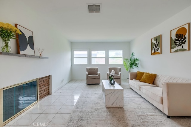 living room with a fireplace and light tile patterned floors