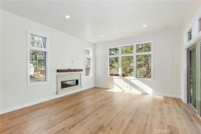 unfurnished living room featuring light hardwood / wood-style floors and a fireplace