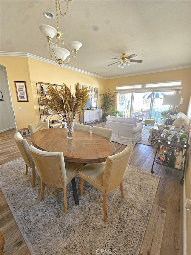 dining room with ceiling fan, dark wood-type flooring, and ornamental molding