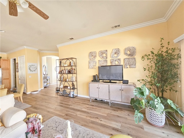 living room with light hardwood / wood-style floors, ceiling fan, and ornamental molding