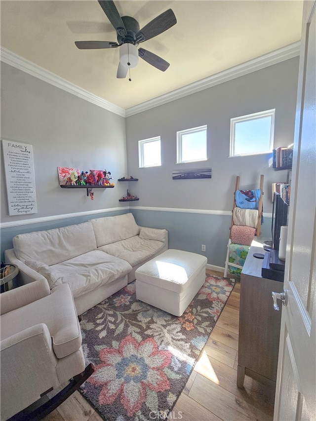 living room featuring light hardwood / wood-style flooring, ceiling fan, and crown molding