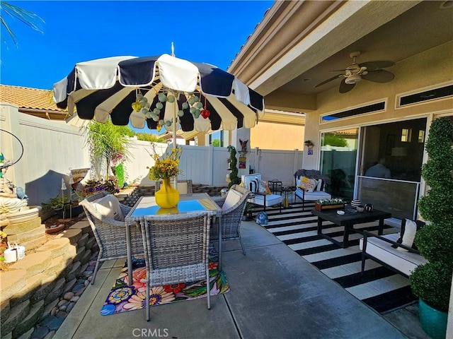 view of patio with a fenced backyard, outdoor dining space, and ceiling fan