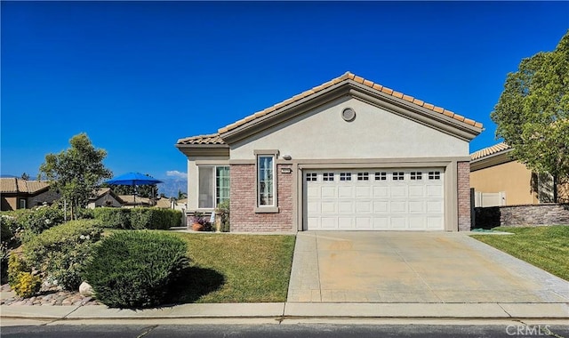 view of front facade with stucco siding, driveway, an attached garage, a front lawn, and a tiled roof
