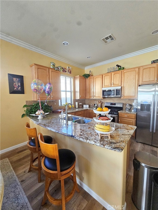 kitchen featuring appliances with stainless steel finishes, tasteful backsplash, crown molding, sink, and dark hardwood / wood-style floors