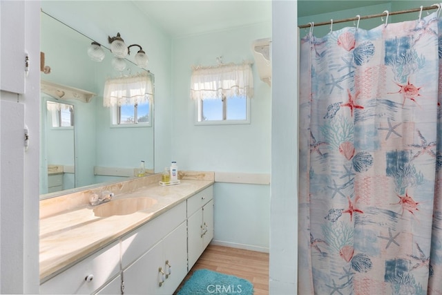 bathroom featuring baseboards, wood finished floors, vanity, and a shower with curtain