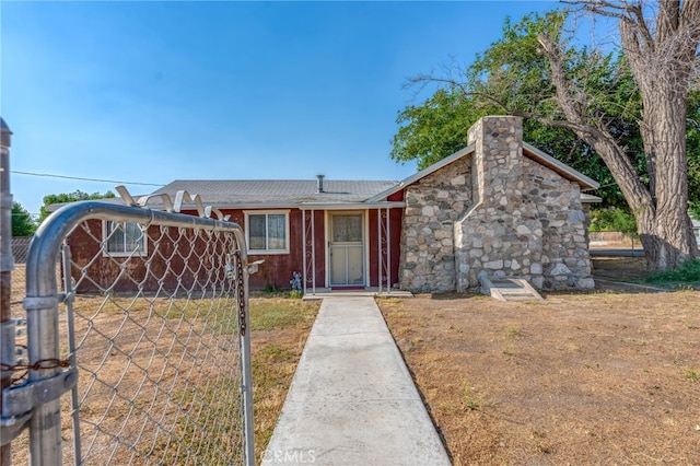 view of front of property featuring a gate, fence, and a chimney