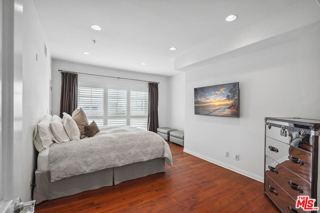 bedroom with dark hardwood / wood-style flooring