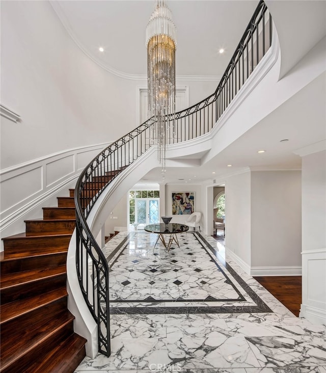 stairway featuring crown molding and a notable chandelier