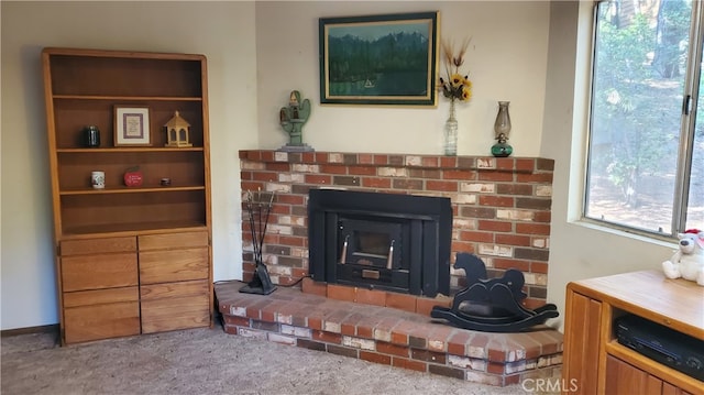 carpeted living room featuring a brick fireplace and a healthy amount of sunlight