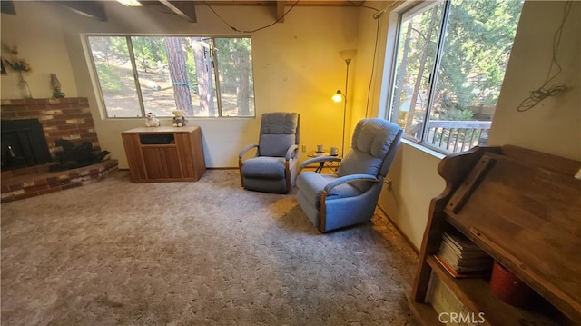 sitting room with carpet floors, a fireplace, and beam ceiling