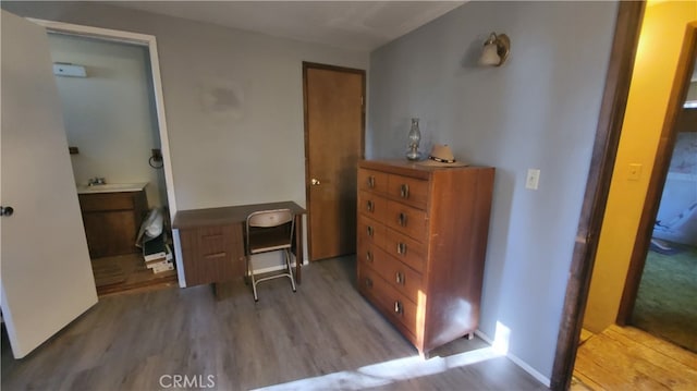 office area featuring connected bathroom and light hardwood / wood-style flooring