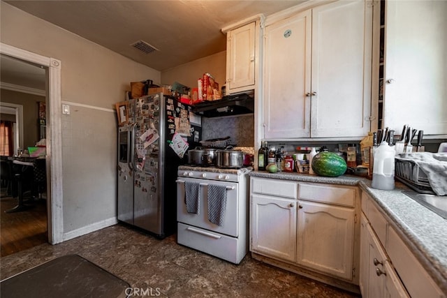 kitchen featuring gas stove, ornamental molding, stainless steel fridge with ice dispenser, and dark tile patterned floors