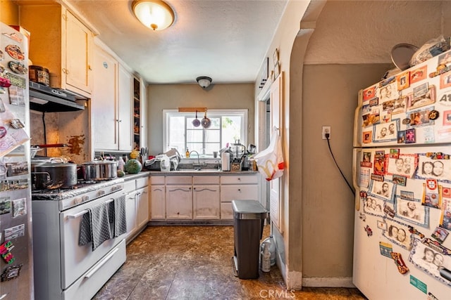 kitchen featuring range with gas cooktop, white refrigerator, a textured ceiling, sink, and stainless steel refrigerator