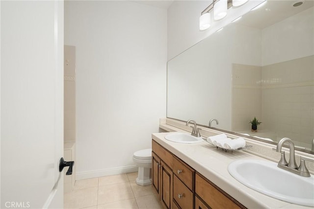 bathroom with toilet, vanity, and tile patterned floors