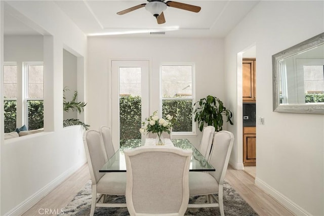 dining space with light wood-type flooring and ceiling fan