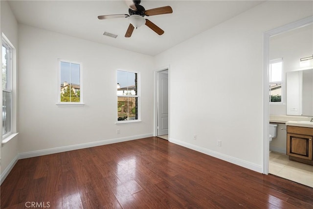 interior space featuring ensuite bath, ceiling fan, and wood-type flooring