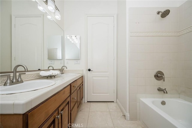 bathroom with tile patterned flooring, tiled shower / bath combo, and vanity