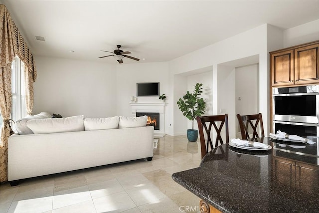 living room with ceiling fan and light tile patterned floors