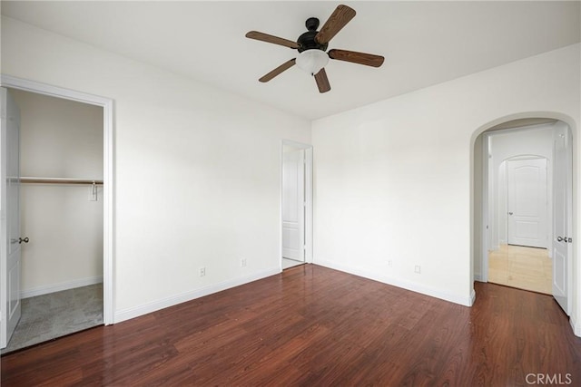 unfurnished bedroom with ceiling fan, a closet, and dark wood-type flooring