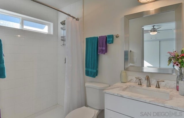 bathroom with toilet, curtained shower, vanity, and ceiling fan