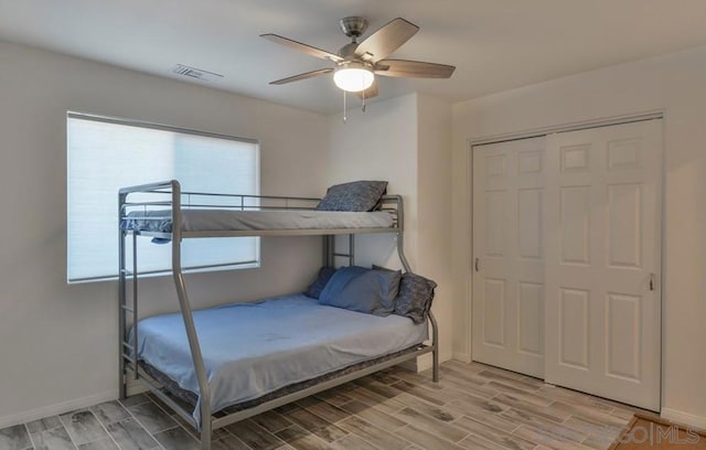 bedroom with a closet, hardwood / wood-style floors, and ceiling fan