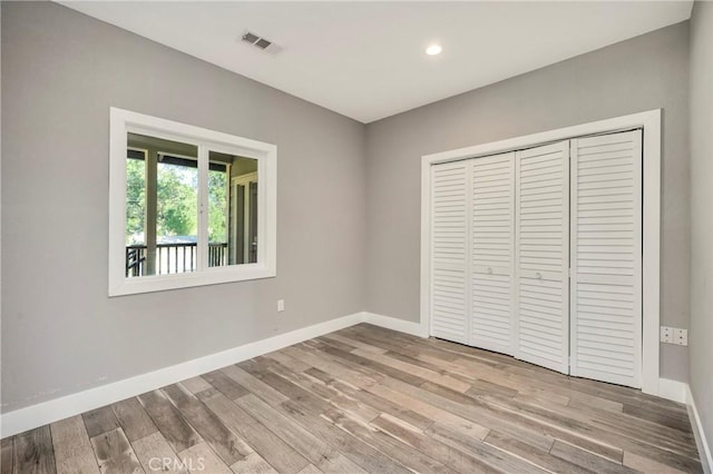 unfurnished bedroom featuring light hardwood / wood-style floors and a closet