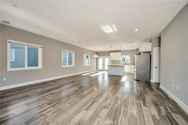 unfurnished living room featuring french doors and hardwood / wood-style flooring