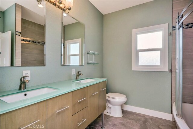 full bathroom featuring toilet, tile patterned floors, vanity, and enclosed tub / shower combo