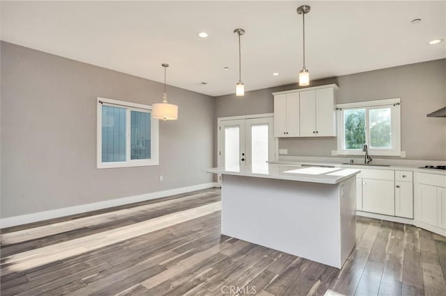 kitchen featuring sink, pendant lighting, white cabinetry, and a center island