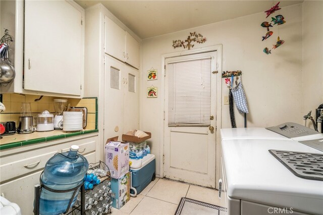 kitchen with white cabinets, light tile patterned floors, backsplash, tile countertops, and independent washer and dryer