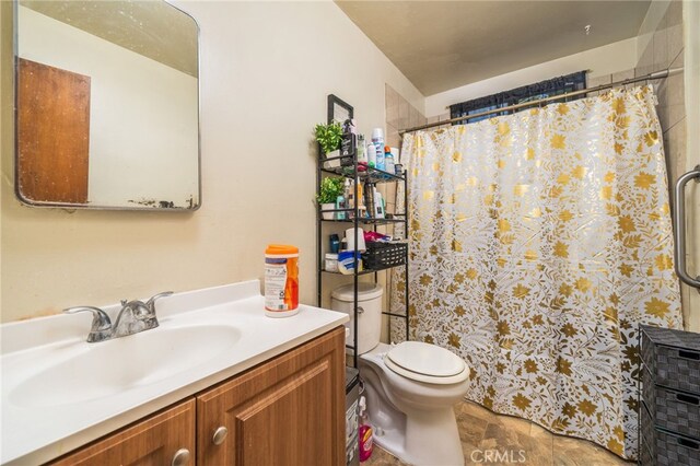 bathroom featuring walk in shower, vanity, and toilet