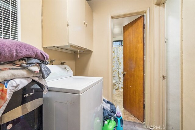 clothes washing area featuring light hardwood / wood-style flooring, washer / clothes dryer, and cabinets